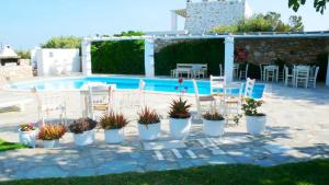 eine Terrasse mit Stühlen und ein Pool mit einem Haufen Pflanzen in der Unterkunft Hotel Anezina in Drios