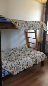 a bottom bunk bed with a floral blanket on it at Kernaveland in Kernavė