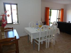una sala da pranzo con tavolo e sedie bianchi di Holiday House ad Albufeira