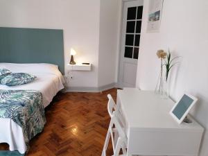 a bedroom with a bed and a desk and a table at Hostel Rossio Alcobaça in Alcobaça