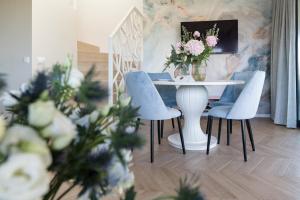 a dining room with a table and chairs and flowers at Aqua Your Stay in Sasino
