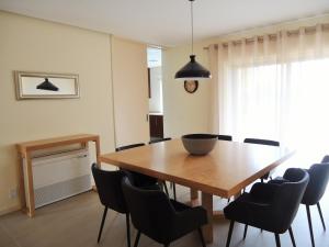 - une salle à manger avec une table et des chaises en bois dans l'établissement Alecrim Lux Tavira Residence Villa 4M, à Luz de Tavira