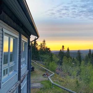 a house with a window and a view of the sunset at The Peak House in Syöte
