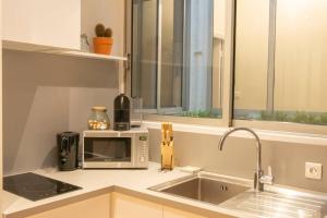 图卢兹Confort Appartement 110 m² CleanNcosy Toulouse Hypercentre的配有水槽和微波炉的厨房