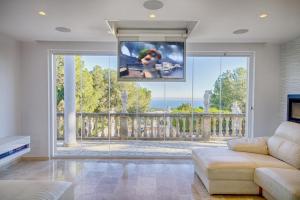 a living room with a large window and a tv at Villa Ocean View in Portals Nous