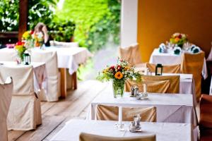 einen Tisch für eine Hochzeit mit weißen Tischen und Blumen in der Unterkunft Hotel Gasthof Lercher in Murau