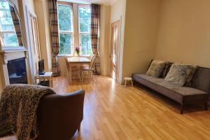 uma sala de estar com um sofá e uma mesa em Cosy and Modern Apartment in Central Edinburgh em Edimburgo