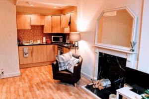 uma sala de estar com uma cadeira e uma lareira em Cosy and Modern Apartment in Central Edinburgh em Edimburgo