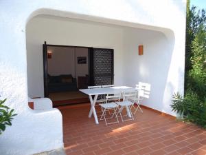 a patio with a white table and chairs on it at Terrace Villa 19B in Santa Luzia