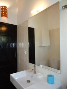 W łazience znajduje się biała umywalka i lustro. w obiekcie Terrace Villa 19B w mieście Santa Luzia