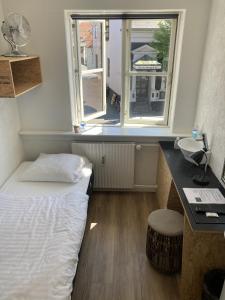 a bedroom with a bed and a sink and a window at Hotel Sniva in Rønne