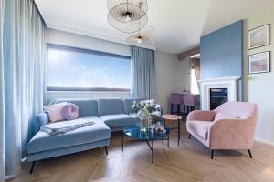 - un salon avec un canapé bleu et une chaise dans l'établissement Aqua Your Stay, à Sasino