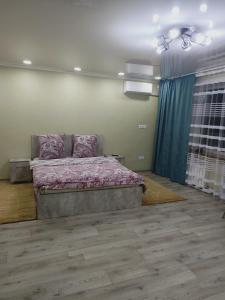 ApartNew in City Centr في أوست - كامينوغورسك: غرفة نوم مع سرير مع وسائد وردية عليه
