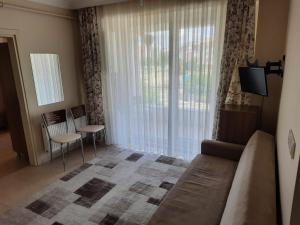 a living room with a couch and a large window at ADA APART OTEL in Çanakkale