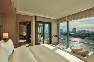 a bedroom with a large bed and a large window at Capella Bangkok in Bangkok