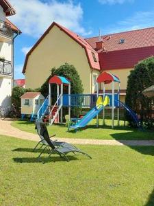 a playground with a slide and a slideintend at Villa Baltica in Łeba