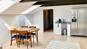a kitchen with a table and chairs and a refrigerator at Tornedalens B&B in Övertorneå