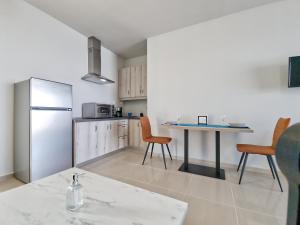 a kitchen with a refrigerator and a table and chairs at Epipleon Luxury Suites -105- Δωμάτιο 35τμ με βεράντα 35τμ μπροστά στη θάλασσα in Nafpaktos