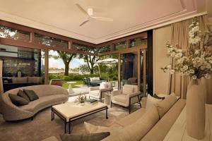 a living room filled with furniture and a ceiling fan at Capella Bangkok in Bangkok