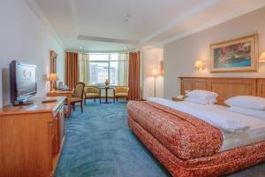 a hotel room with two beds and a television at Bristol Hotel in Amman