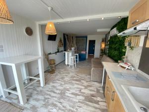 una cucina e un soggiorno con lavandino e tavolo di Cap D'agde Naturiste Heliopolis 2 à 4 Personnes Appartement OSMOSE a Cap d'Agde