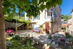 ein Haus mit einer rosa Tür und einem Hof in der Unterkunft Oldtown 1 in Baška