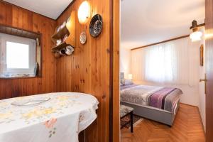 ein Schlafzimmer mit einem Bett und einem Tisch in einem Zimmer in der Unterkunft Oldtown 1 in Baška