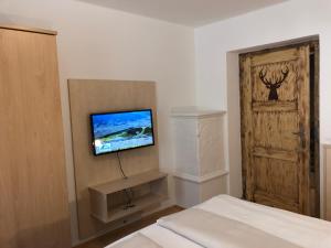 sypialnia z łóżkiem i telewizorem na ścianie w obiekcie Familienappartements Eder - Free entry to Tauern SPA Kaprun included w Kaprunie