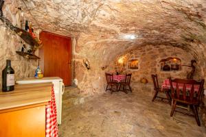 a stone room with chairs and a table in a cave at Ethno house OSOBAK in Virpazar