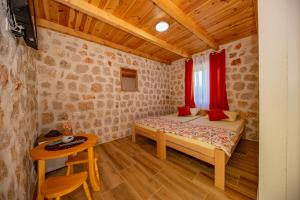 Dormitorio pequeño con cama y mesa en Ethno house OSOBAK en Virpazar
