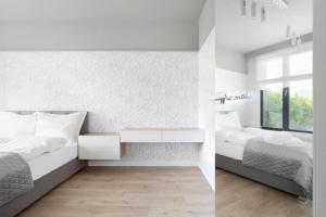 sypialnia z 2 łóżkami i biurkiem w obiekcie VIU Apartament Jelitkowo z ogrodem i parkingiem w Gdańsku