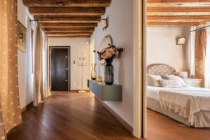 a bedroom with a white bed and a vase of flowers at Corte Contarina San Marco Apartment R&R in Venice