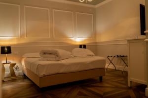 a bedroom with a bed with white sheets and pillows at Locanda Gaudemus Boutique Hotel in Sistiana
