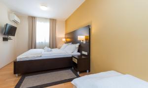 Una habitación de hotel con dos camas y un espejo. en Levant 200 in Marina Portoroz by Locap Group, en Portorož