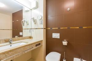 Un baño con lavabo, inodoro y espejo. en Levant 200 in Marina Portoroz by Locap Group, en Portorož 18 fotos más