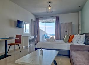 a hotel room with a bed and a table at Epipleon Luxury Suites -105- Δωμάτιο 35τμ με βεράντα 35τμ μπροστά στη θάλασσα in Nafpaktos
