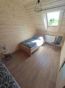 Habitación con cama en una cabaña de madera en Słoneczny Domek, en Kluszkowce