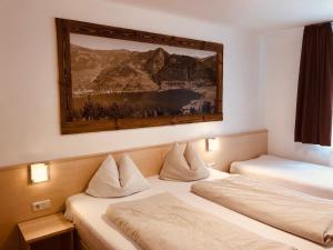 pokój hotelowy z 2 łóżkami i zdjęciem na ścianie w obiekcie Familienappartements Eder - Free entry to Tauern SPA Kaprun included w Kaprunie