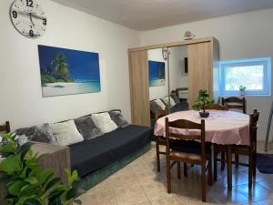a living room with a table and a couch at EMSO apartmani in Novalja