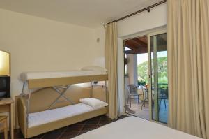a bedroom with a bunk bed and a balcony at Castelsardo Resort Village in Castelsardo