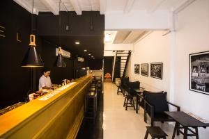 a man standing at a bar in a restaurant at Chatel BKK in Bang Rak