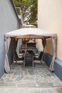 een tafel en stoelen onder een parasol op een patio bij RENT A HOME DANA in Porto Rafti