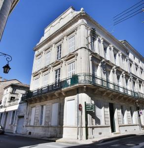 - un bâtiment blanc avec un balcon dans une rue dans l'établissement Meublés de l'Arsenal cœur de ville !, à Angoulême