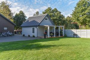 a small house with a white fence and a yard at Vila Renata Laure in Palanga