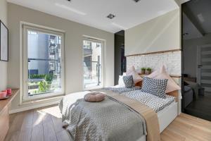 a bedroom with a large bed with pillows on it at NORDBYHUS Apartamenty Chmielna Park in Gdańsk