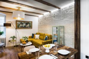 Una sala de estar con un sofá amarillo y una mesa. en Uroczy Apartament Łazienna 5/4, en Toruń