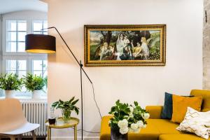 Una sala de estar con un sofá amarillo y un cuadro en la pared. en Uroczy Apartament Łazienna 5/4, en Toruń