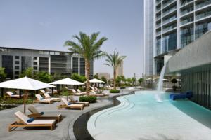 a pool at a hotel with lounge chairs and a fountain at 5 star residence - Burj Khalifa & Fountain views in Dubai