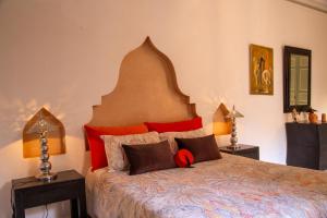 a bedroom with a large bed with red pillows at RIAD KERDOUSS in Marrakesh