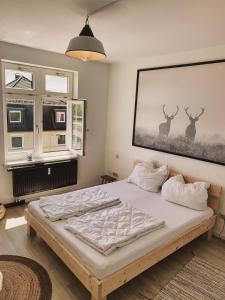 a bedroom with a bed with a picture of deer on the wall at FeWo Braustube Alte Brauerei Friedrichshafen in Friedrichshafen